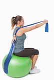 Cute woman stretching her arms with a resistance band