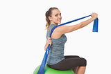 Pretty fit woman stretching her arms with a resistance band