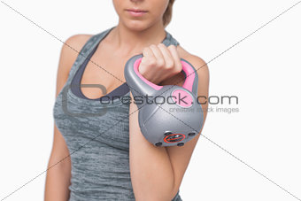 Mid section of young woman working with kettle bell