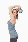 Side view of smiling woman training with kettle bell