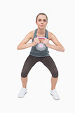 Young woman training her body with a kettle bell