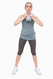 Cute woman training her body with a kettle bell