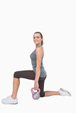 Cheerful woman lunging and using a kettle bell