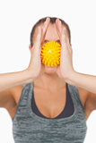 Young woman holding yellow massage ball between hands