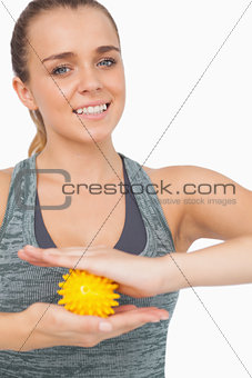 Attractive woman holding yellow massage ball between her hands
