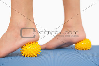 Female feet touching yellow massage ball