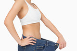 Mid section of slim young woman wearing too big jeans
