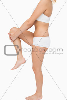 Sporty woman stretching her legs