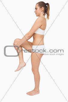 Cute ponytailed woman stretching her legs
