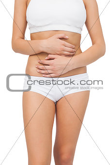 Slim woman touching her belly with her hands