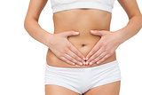 Mid section of slim woman touching her belly with her hands
