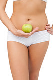 Close up of slim woman holding a green apple