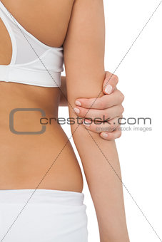Young fit woman touching her elbow