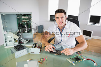 Handsome smiling computer engineer holding stethoscope