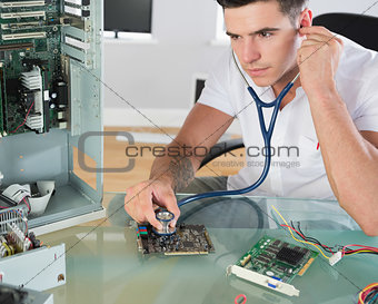 Handsome stern computer engineer holding stethoscope