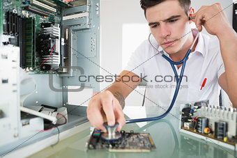 Handsome focused computer engineer holding stethoscope