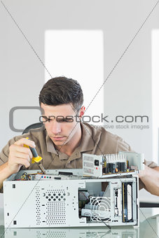 Handsome serious computer engineer repairing open computer