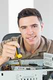 Handsome happy computer engineer repairing open computer