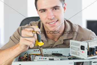 Handsome content computer engineer repairing open computer