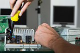 Computer engineer repairing hardware with screw driver