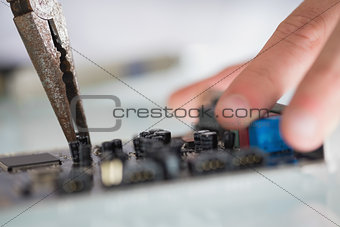 Extreme close up of pliers repairing hardware held by hand