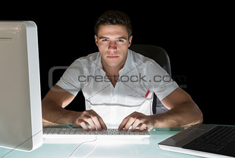 Handsome frowning computer engineer working at night