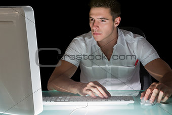 Handsome focused computer engineer working at night