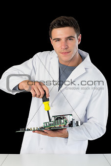 Attractive smiling computer engineer repairing hardware at night