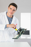 Attractive content computer engineer repairing hardware with screw driver