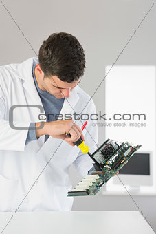 Attractive computer engineer repairing hardware with screw driver