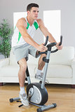 Determined handsome man training on exercise bike
