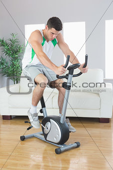 Sporty handsome man training on exercise bike