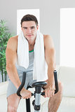 Happy handsome man training on exercise bike