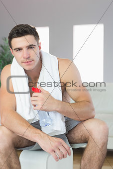 Content handsome man sitting holding water bottle