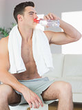 Handsome sporty man drinking from water bottle