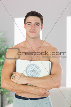 Confident handsome man holding scales