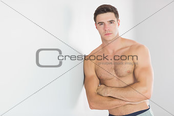 Sexy handsome man leaning topless against wall