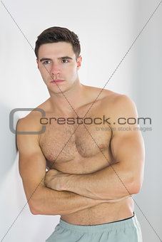 Focused handsome man leaning topless against wall