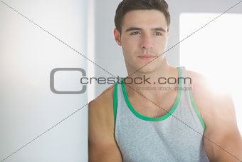 Stern handsome man leaning against wall