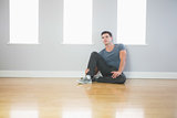 Thinking handsome man leaning against wall sitting on the floor