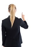Rear view of ponytailed blonde businesswoman pointing