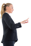 Low angle side view of blonde businesswoman pointing upwards