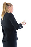 Ponytailed blonde business woman pointing upwards