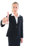 Serious attractive businesswoman pointing upwards
