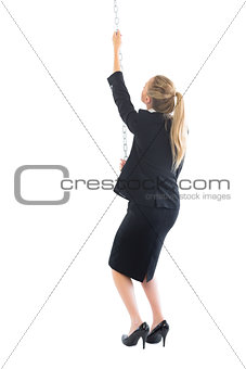 Ponytailed chic businesswoman pulling a chain
