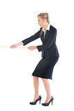 Focused blonde businesswoman pulling a rope