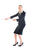 Cheerful blonde businesswoman pulling a rope