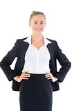 Cheerful young businesswoman posing with hands on hips