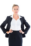 Serious young businesswoman posing with hands on hips