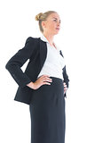 Low angle view of blonde businesswoman posing with hands on hips